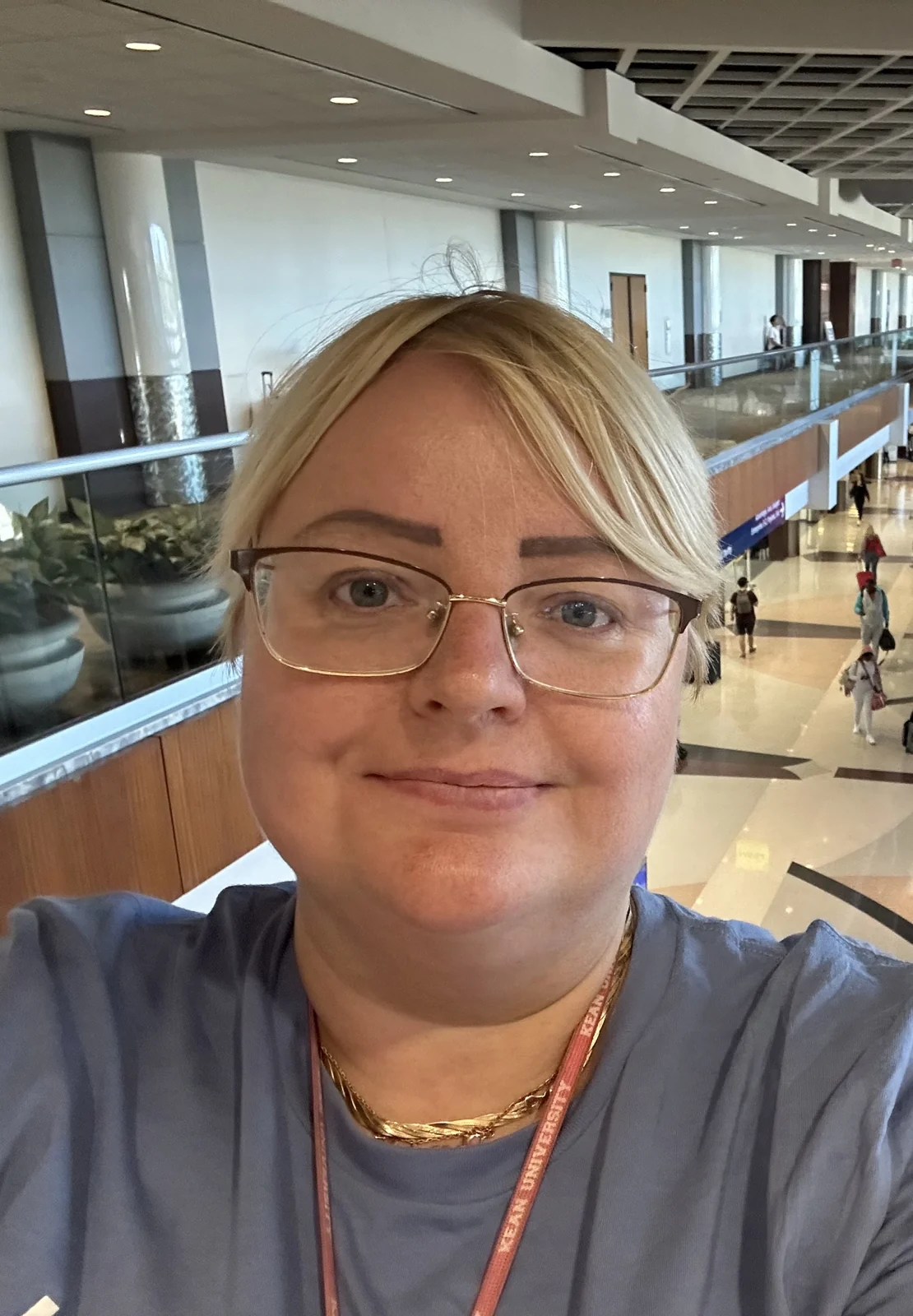 Julie in a bright atrium with a glass balcony