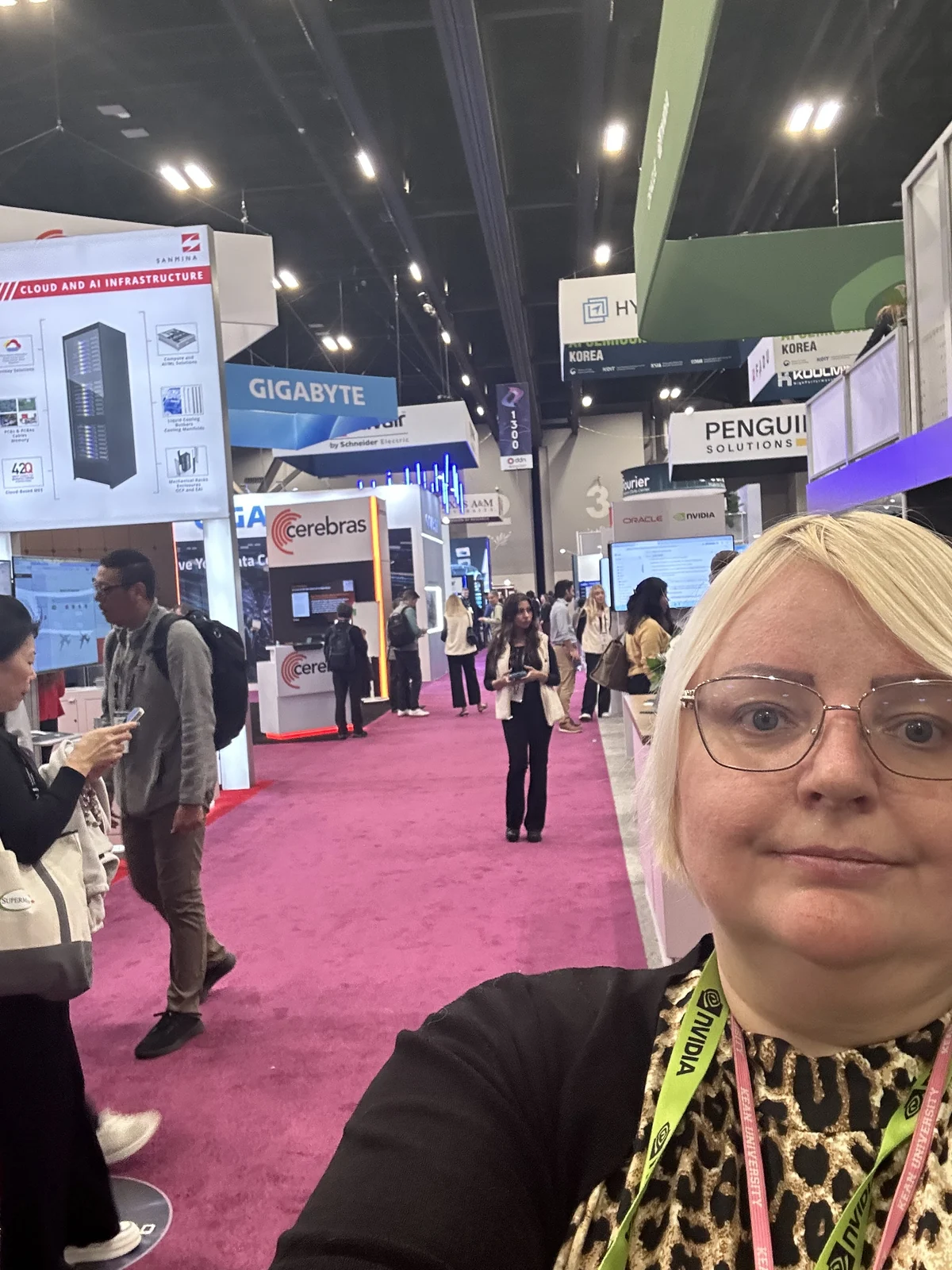 Julie at Supercomputing 2025, with computing and AI exhibition booths in the background